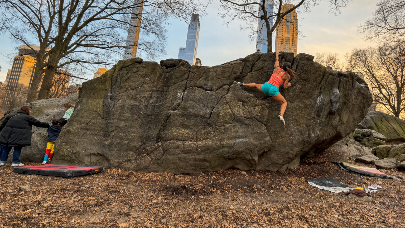 Rock climber on Manhattan schist with NYC skyline